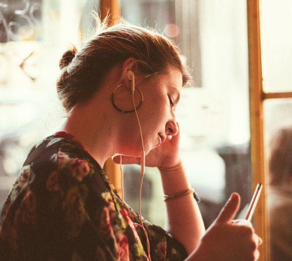 Woman using headphones to listen to a mobile device